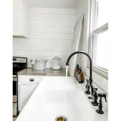Kingston Brass Tudor Bridge Deck Mount Kitchen Faucet with Brass Sprayer