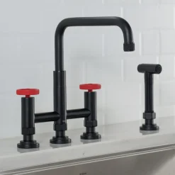 KRAUS Urbix Bridge Kitchen Faucet with Side Sprayer in Matte Black/Red